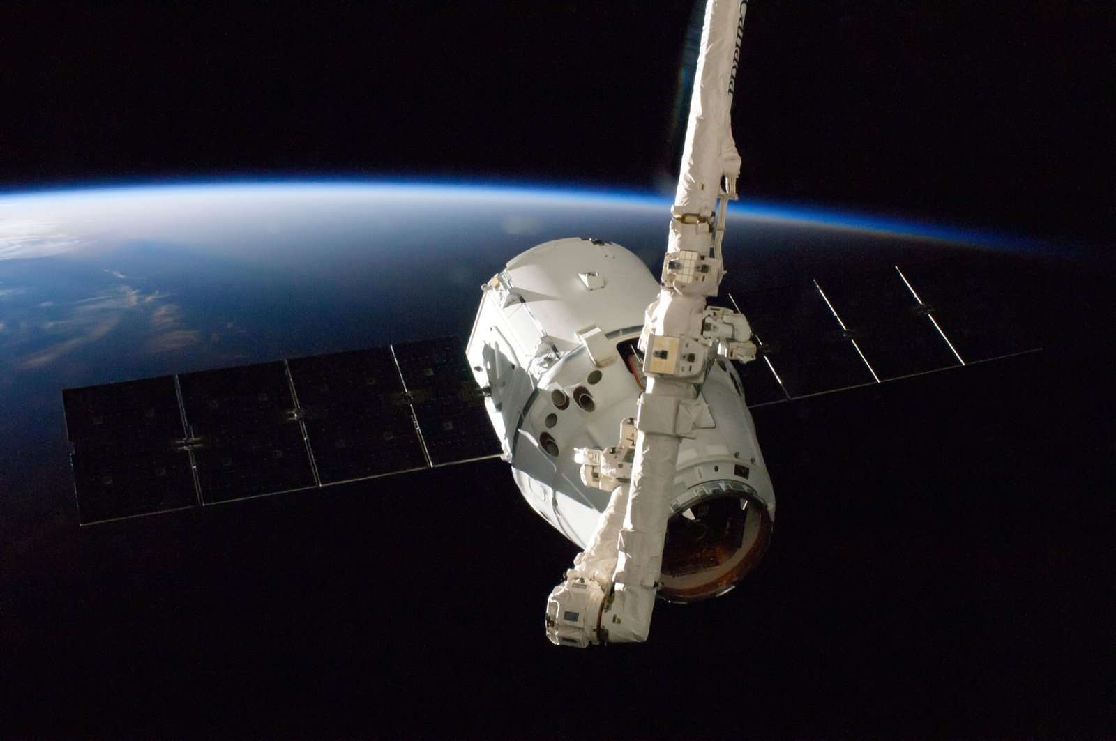 SpaceX Dragon kapsule v dokovací pozici – ilustrace satelitních misí